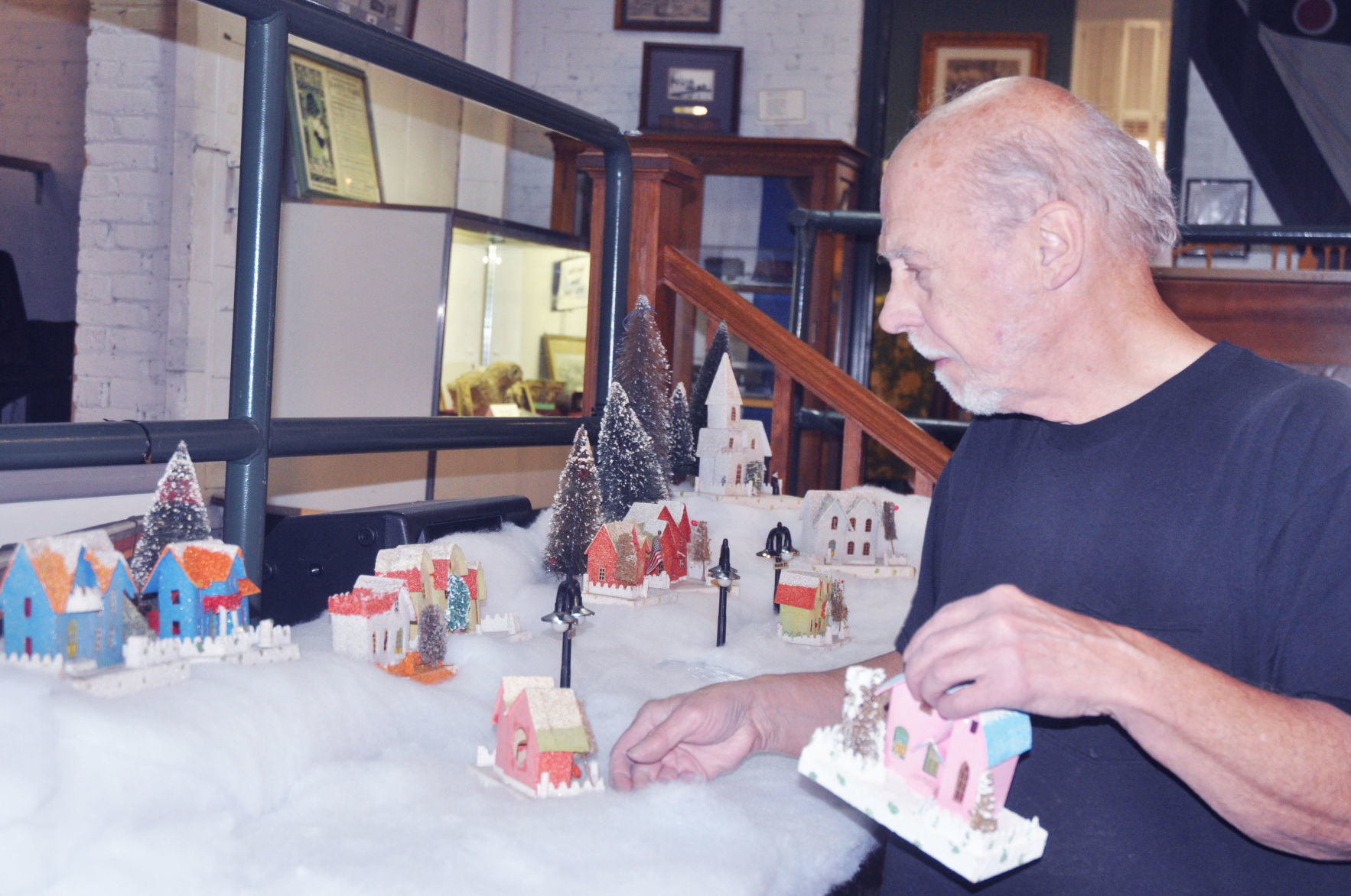 Pete Oehmen of Lake Geneva places some putz houses that he plans to display during the holiday season